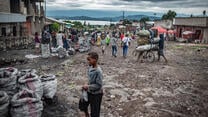 A young boy and other people on the street in Goma, DRC on a cloudy day