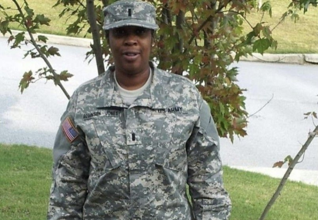 Stacy Robinson standing in a front yard wearing her Army uniform.