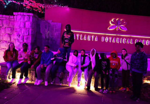 A group photo of Youth Futures staff and students sitting outside of the Atlanta Botanical Garden.