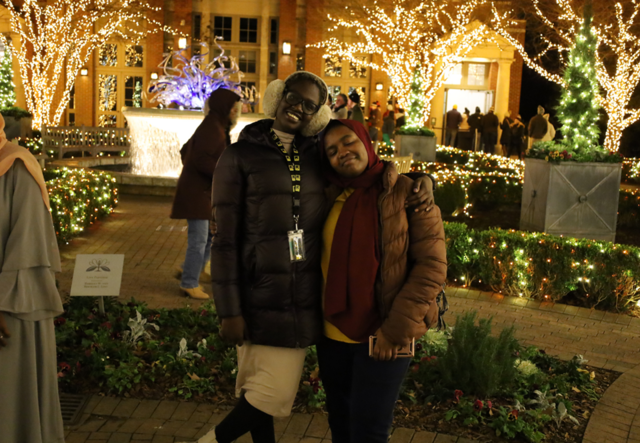 Student Support Specialist Ajok Dut and a Youth Futures student smile at Garden Lights, Holiday Nights.