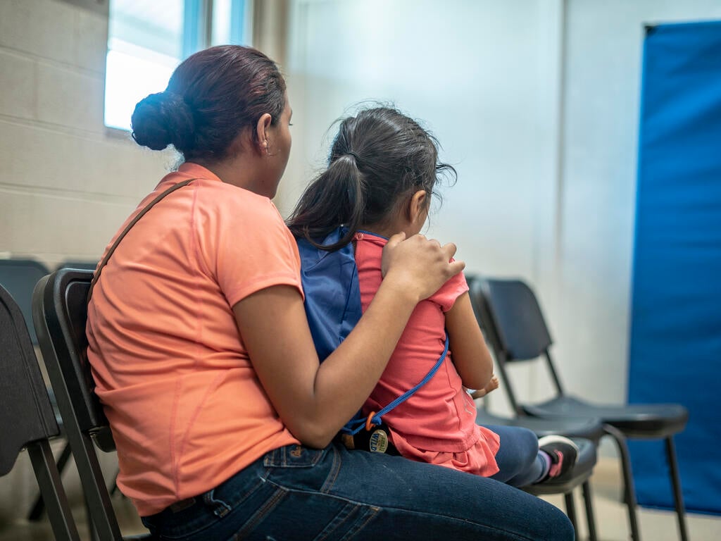 Emilia sits with her arms around four-year-old Lauda in a shelter in Phoenix, Arizona for asylum-seeking families who were released from detention at the U.S. border