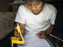 A girl in Latin America using a WakaWaka solar light to do her homework. 