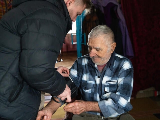 Nurse Stanislav measures Volodymyr’s blood pressure. 