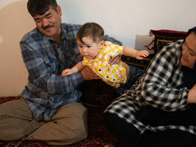 Hazar holds his one-year-old son, Mahdi.