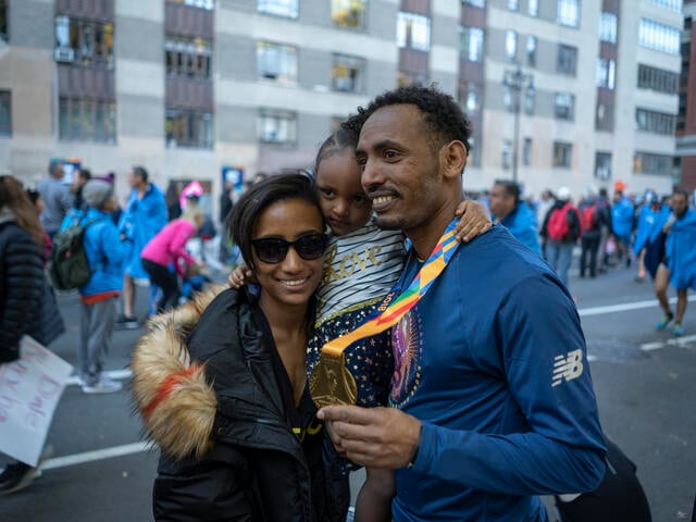 Tolassa Elemaa and his wife Bikiltu hold their daughter in Manhattan after the 2018 NYC Marathon