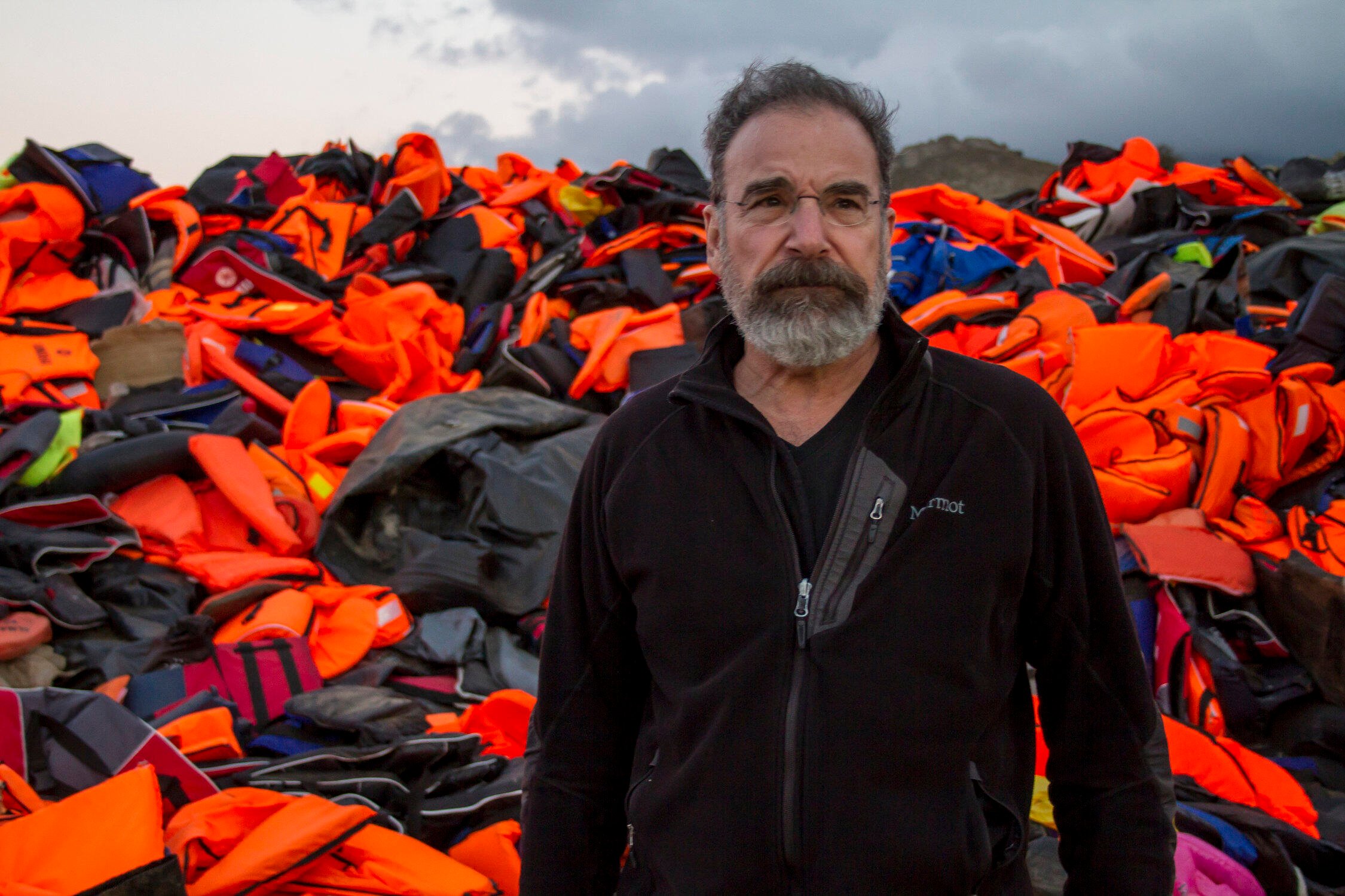 Mandy Patinkin on the island of Lesbos, Greece with lifejackets used by refugee