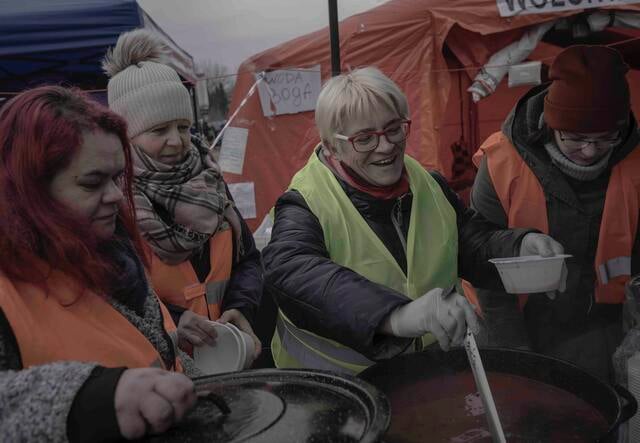 Volunteers distribute meals to Ukrainian refuges at the Tesco reception center, Przemysl, Poland
