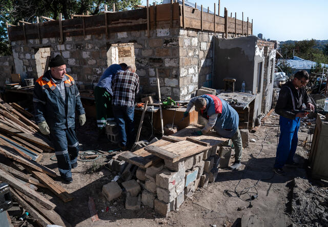 Workers amongst the rubble of Maryna and Serhii's home.