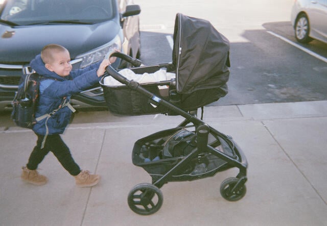 Oleskii pushes his baby brother in the stroller
