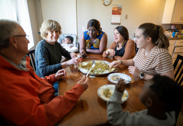 Group of volunteers sharing Congolese meal with Congolese family
