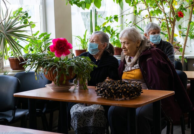 Alla sits beside one of her friends at the nursing home