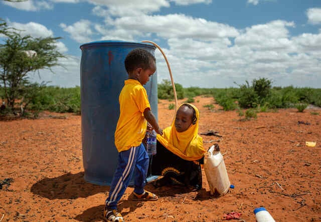 Två små barn hämtar vatten. 