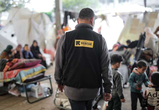 An IRC officer walks through a makeshift camp for internally displaced children in Gaza.