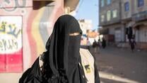 Tahani is fully veiled and is walking in a street