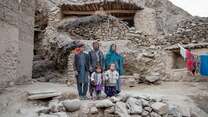 A family poses for a photo together, outside of their rural home in Bamiyan province, Afghanistan.
