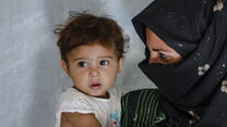 Syrian refugee with her baby daughter at a tented settlement in Lebanon