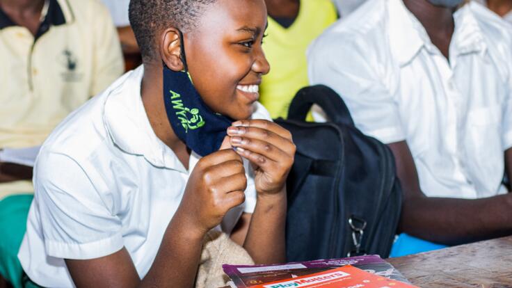 A girl smiles in school during a PlayMatters session.