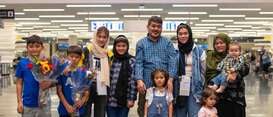 A family poses for a photo together after being reunified at an airport.