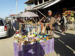 A street vendor standing by his stall
