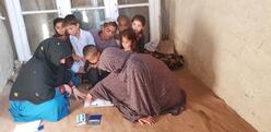 women and children sitting on the floor talking to each other