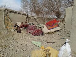 A family sitting in the backyard of their destroyed house