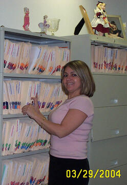 Nadeana standing by her clients files in her office (2004)