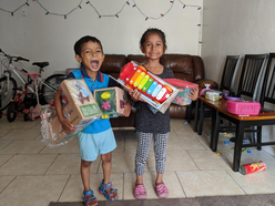 Two kids excitedly holding toys.