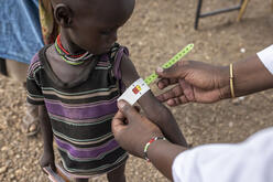 Ministry of Health (MoH) nutritionist screens child for malnutrition in Kenya