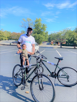 Man holding baby with bike