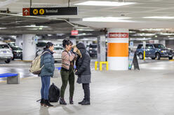 IRC staff welcoming newcomer at airport wearing winter clothing