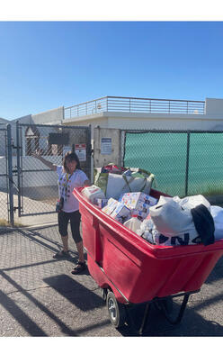 Welcome Center volunteer, Pnina, with a bucket full of clothing for the Ropa Room.