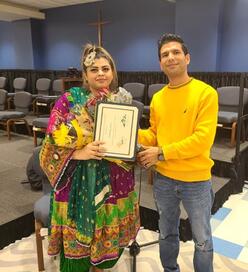 Woman standing with a certificate in hand standing with a man