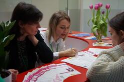 Two women helping another woman through the employment process.