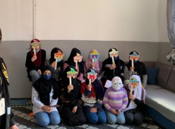Fahima with her new support network following a mask-painting activity. 