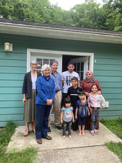 This is a photo of a Co-Sponsor team and a newly arrived family of five