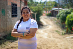 Omaira, a Women’s Protection and Empowerment Advocate standing proudly outside of a building in Colombia.