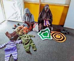 Aishatu and Nana knit traditional Tumakasa hats and clothes from IRC's safe space.