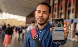 An IRC Italy client holding mobile phone showing Refugee.info resource