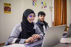 Afghanische Frau und Mann in Deutschland beim gemeinsamen Arbeiten am Laptop.