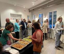 People enjoying food, drinks, and talking with each other at event reception.