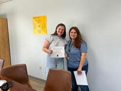 Olesia holds up certificate