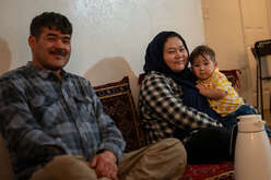 A family holds their young child. 