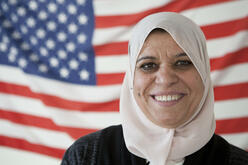 Bushra Naji stands before an American flag