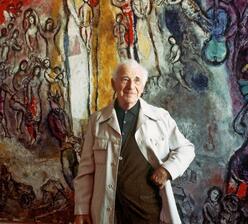 Artist and elderly man Marc Chagall stands in front of his artwork