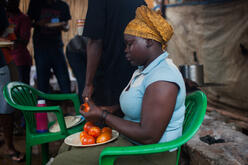 An employee slices tomatoes for lunch.