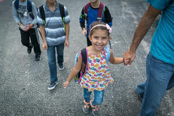  5-year-old Jori walks to school holding her father's hand