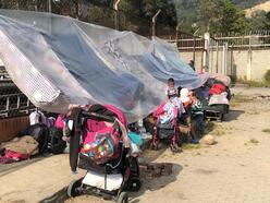 Venezuelans attempting to walk back home create a makeshift tent to shield themselves from the sun. 