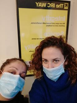 Two women wearing face masks taking a selfie