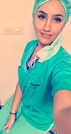 Dr Rose Al-Nsour takes a selfie in her doctors scrubs