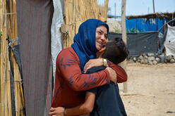 Yasser with his mother outside the family's tent in a camp for displaced people in northeast Syria. 